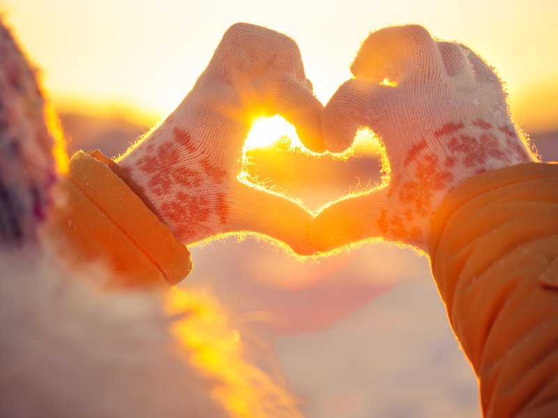Life Extension, hands with gloves making a heart around the sun on a winter day